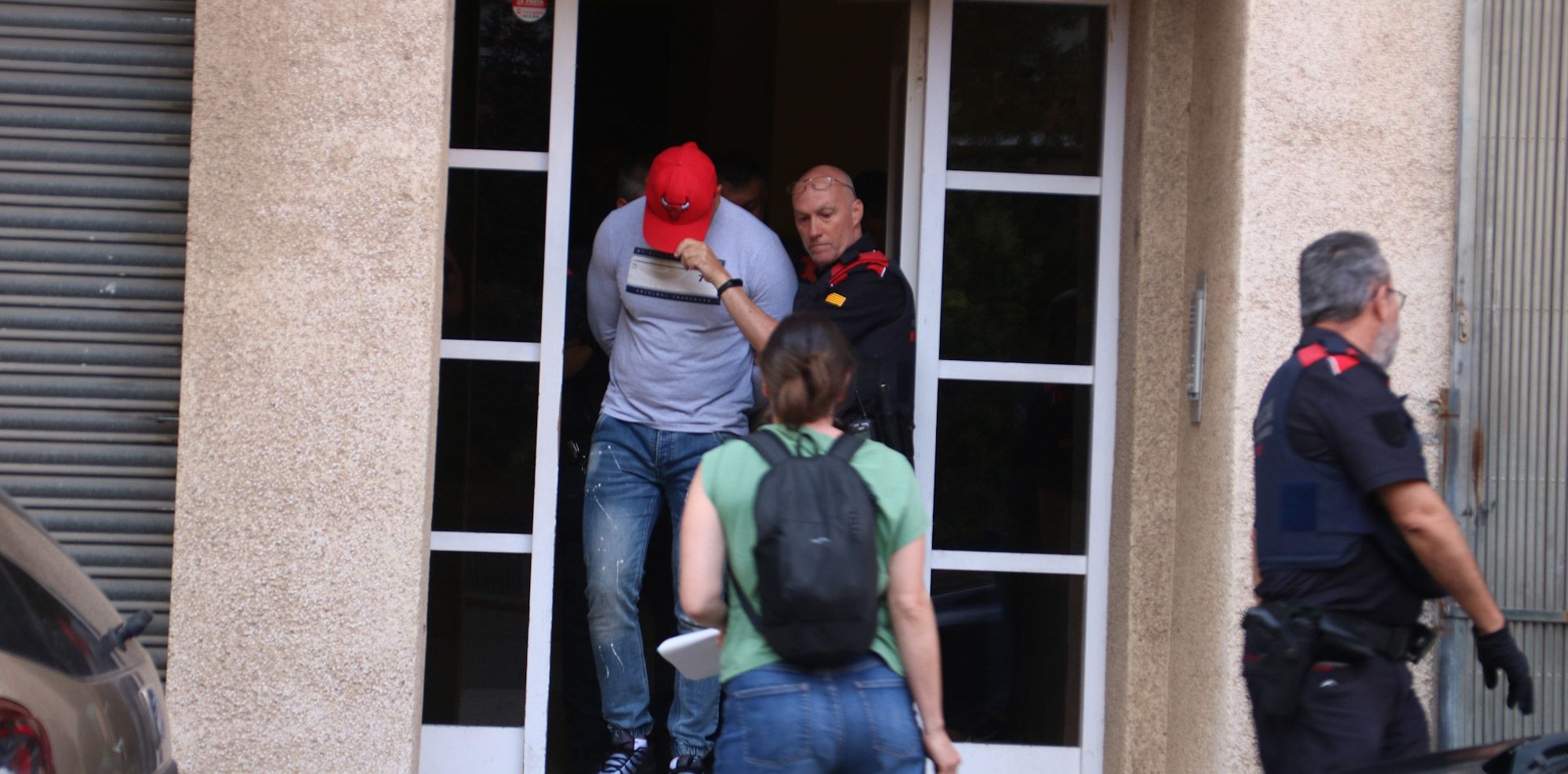 Agents dels Mossos d'Esquadra custodiant un home detingut en l'operatiu antidrogues fet a Valls