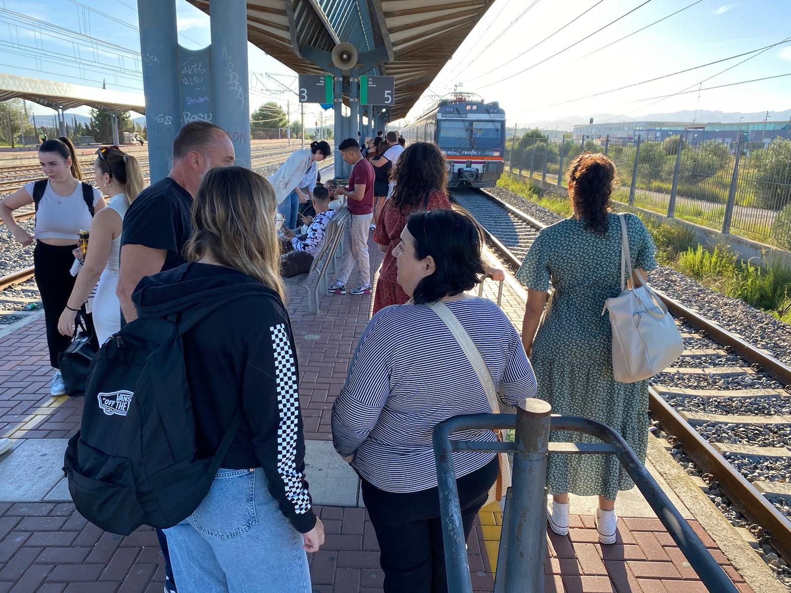 Viatgers de la línia R-16 esperant al tren a l'estació de l'Aldea-Amposta-Tortosa