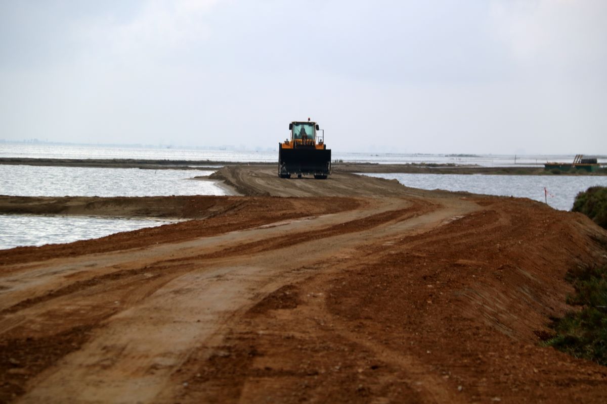 Una excavadora circula pel nou vial d'accés a les Salines de la Trinitat a la barra del trabucador  D