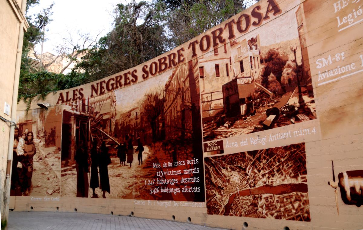 Mural d'art urbà de Roc Blackblock pintat a l'entrada del carrer Hemingway on es pot visitar un dels refugis antiaeris de la Guerra Civil de Tortosa