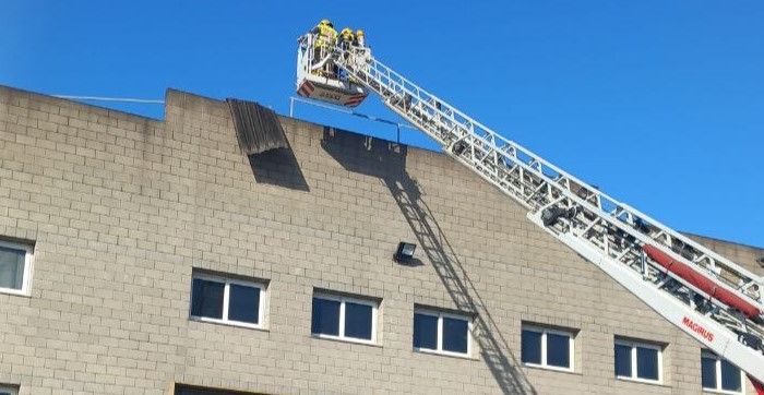 Imatge de l'autoescala dels Bombers treballant en una nau a Tortosa   