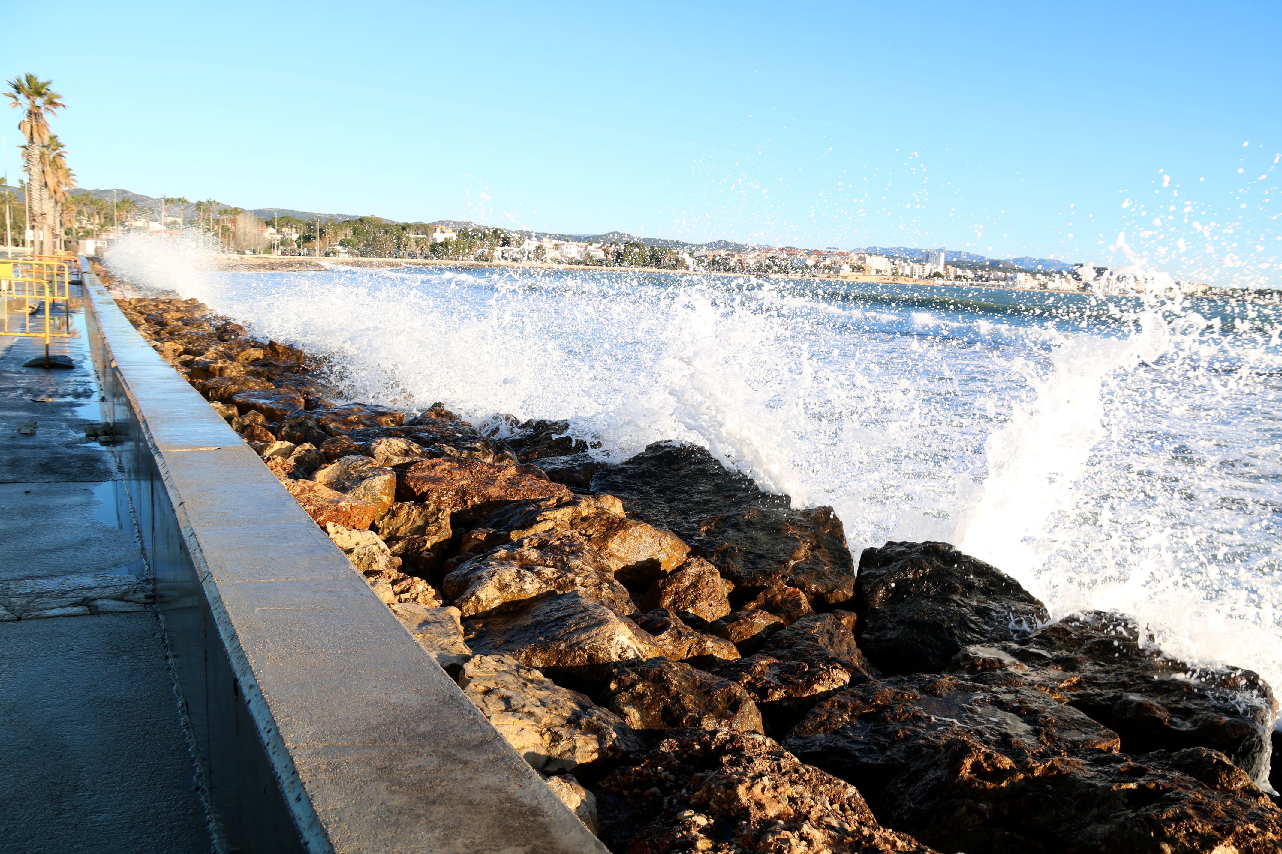 Ones bategant al mur de pedres que va substituir la desapareguda platja de l'Arenal de l'Ampolla després del Gloria